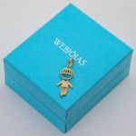 Pingente-em-ouro-18k-amarelo-filhos-menino-com-zirconias-brancas-em-cima-da-caixinha-de-joia-webjoias